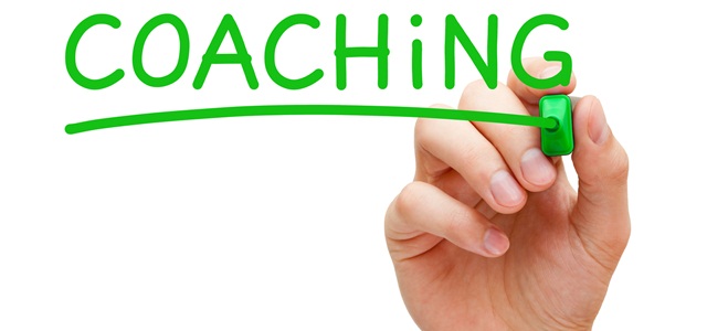 mão escrevendo coaching na tela