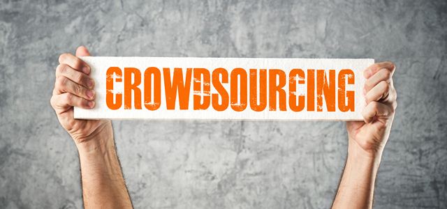 mãos segurando placa com a palavra crowdsourcing