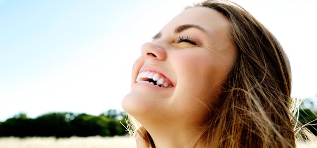 Jovem mulher sorrindo muito feliz, mostrando como sorrir faz bem, é bom
